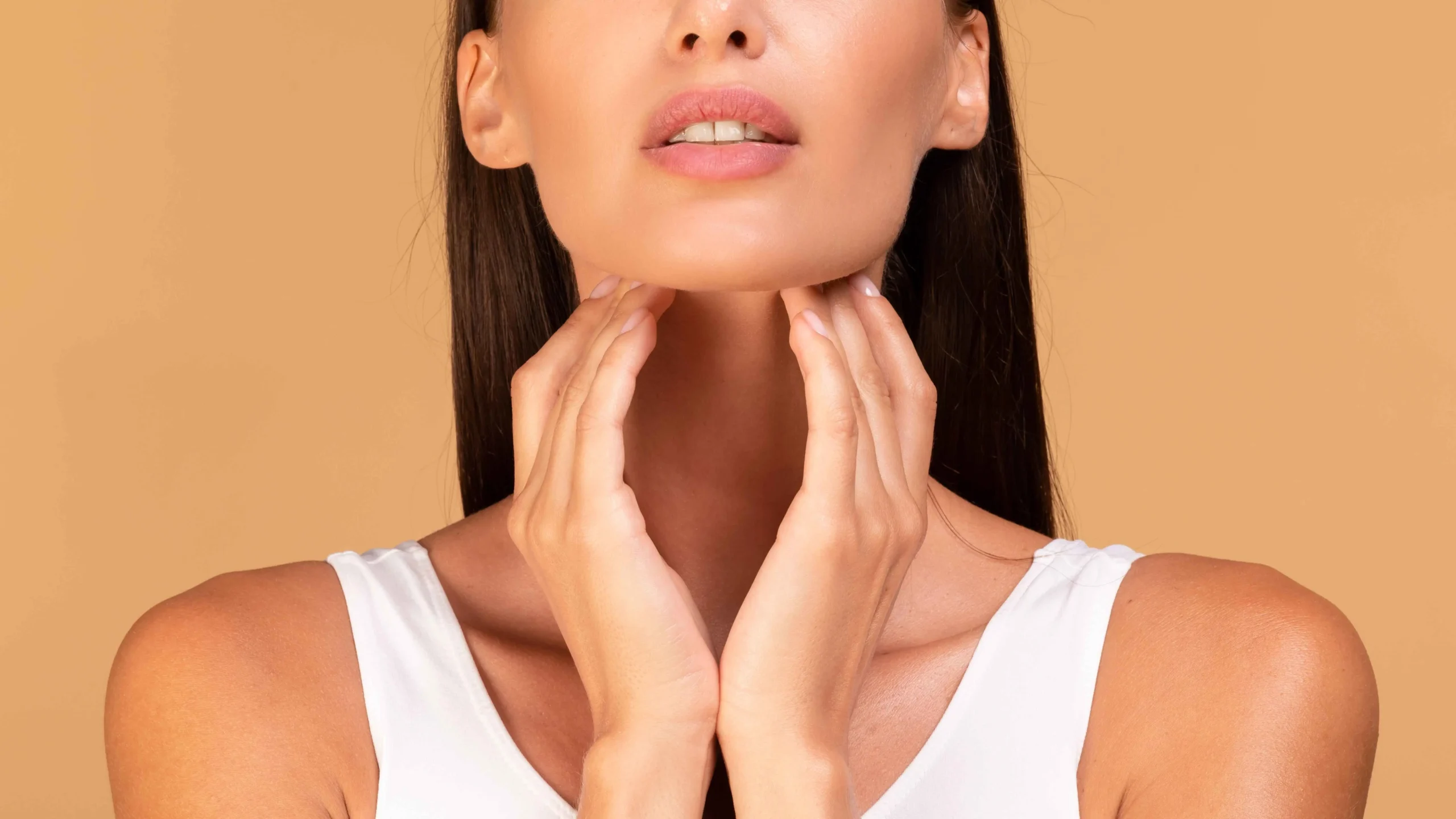 closeup shot young woman suffering from pain throat touching her neck panorama beige studio background scaled